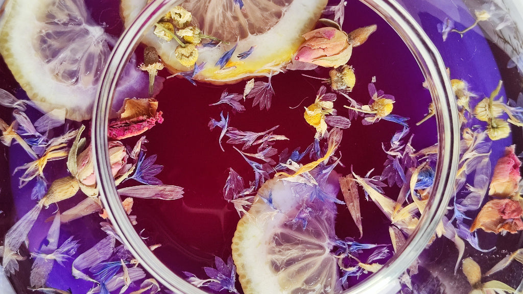 Blauer Tee mit Zitrone Lila mit Blüten dekoriert in der Kanne